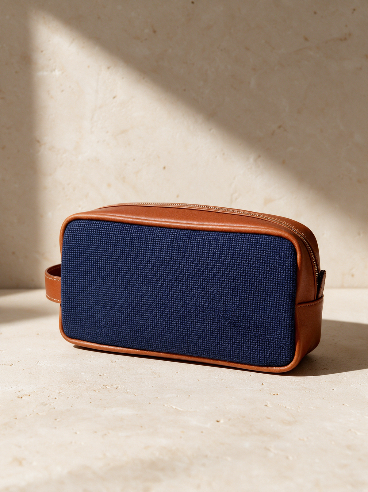 The Needlepoint Toiletry Bag in a warm stone setting