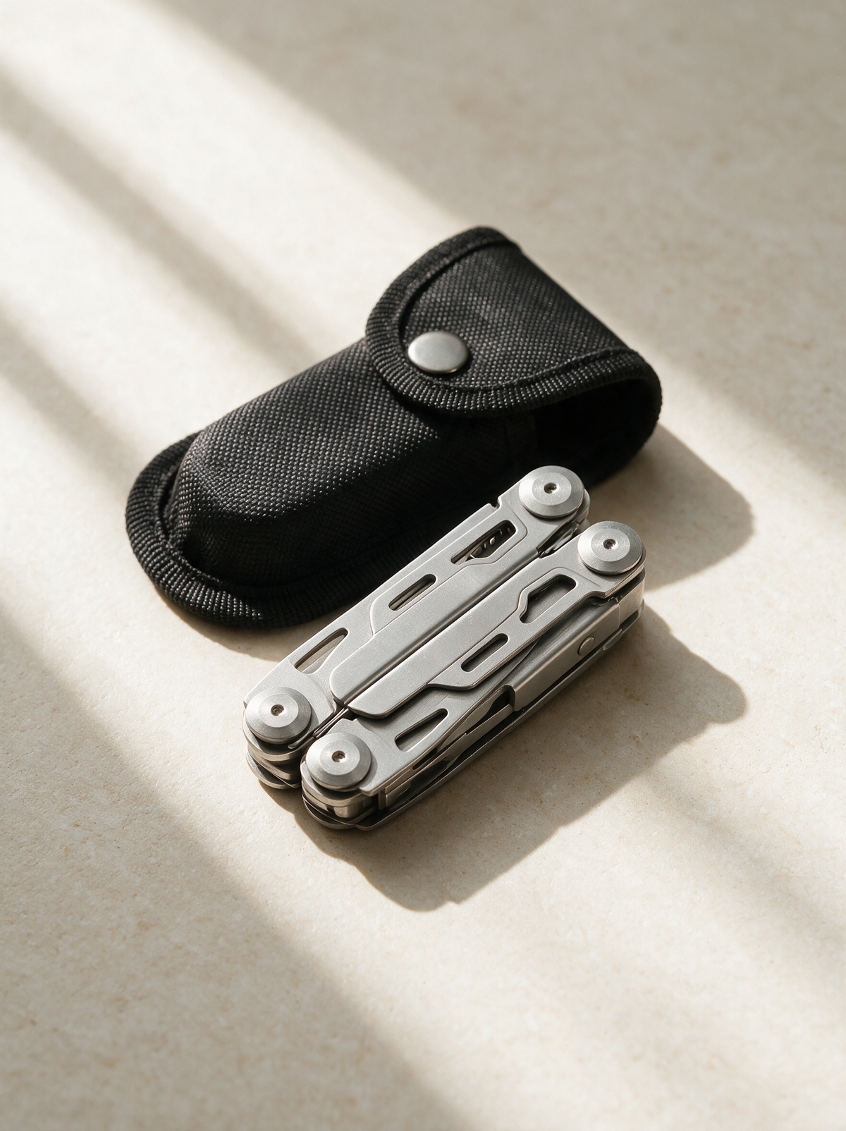 Outdoor multi tool with its sheath, on warm stone