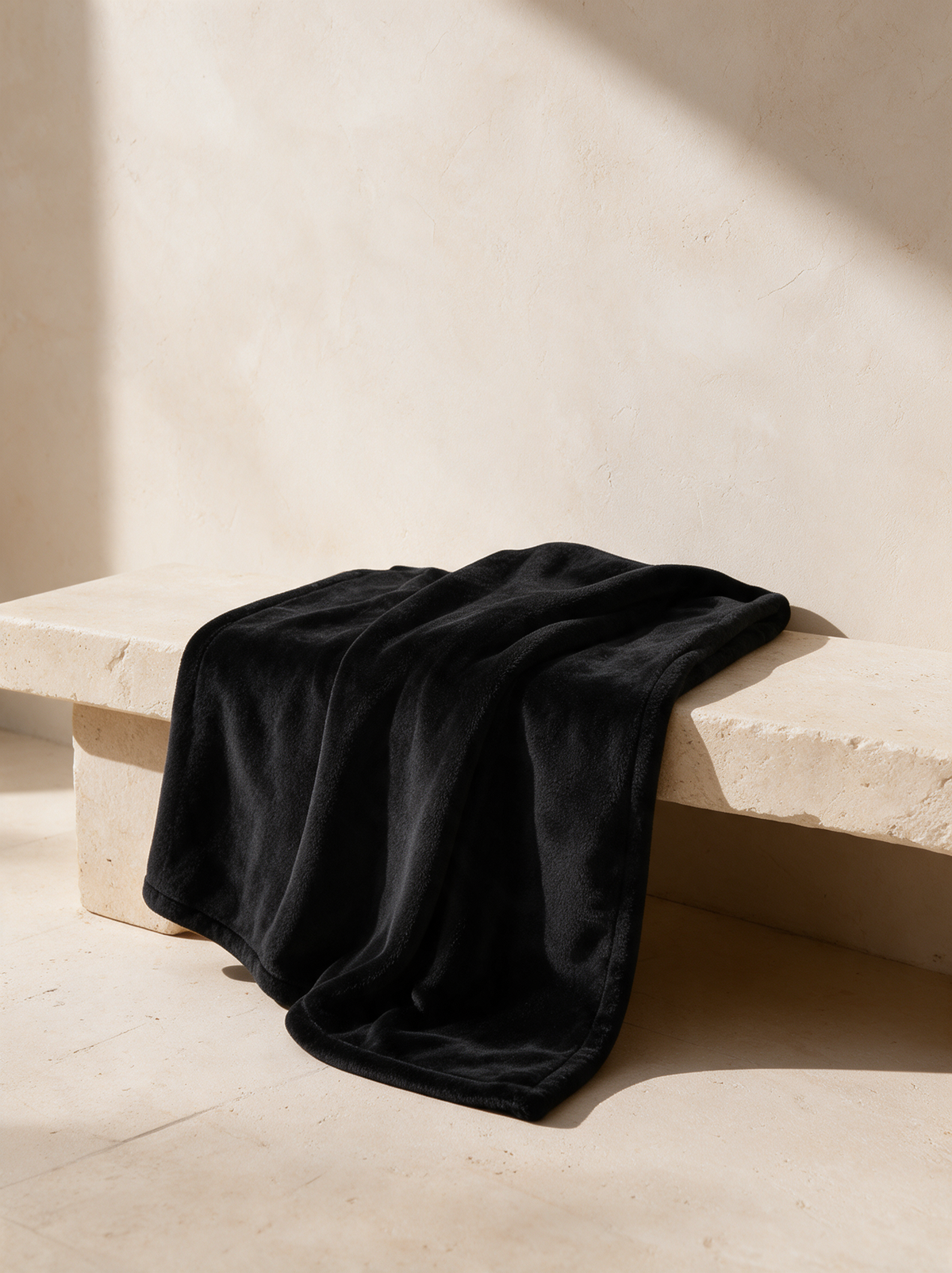 Throw blanket, Black, draped over a stone bench