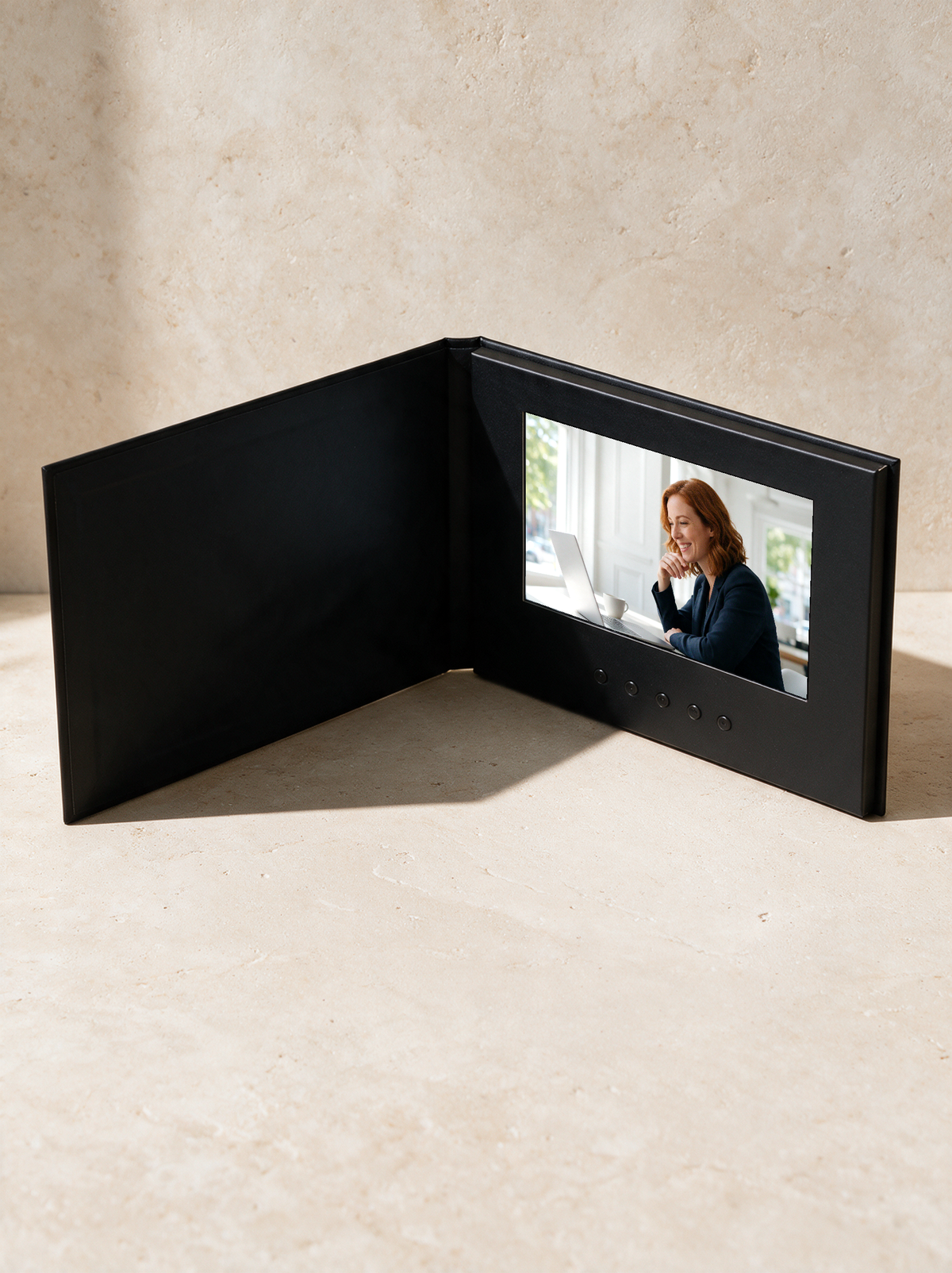 Video brochure opened like a book, a video playing on its 7-inch screen